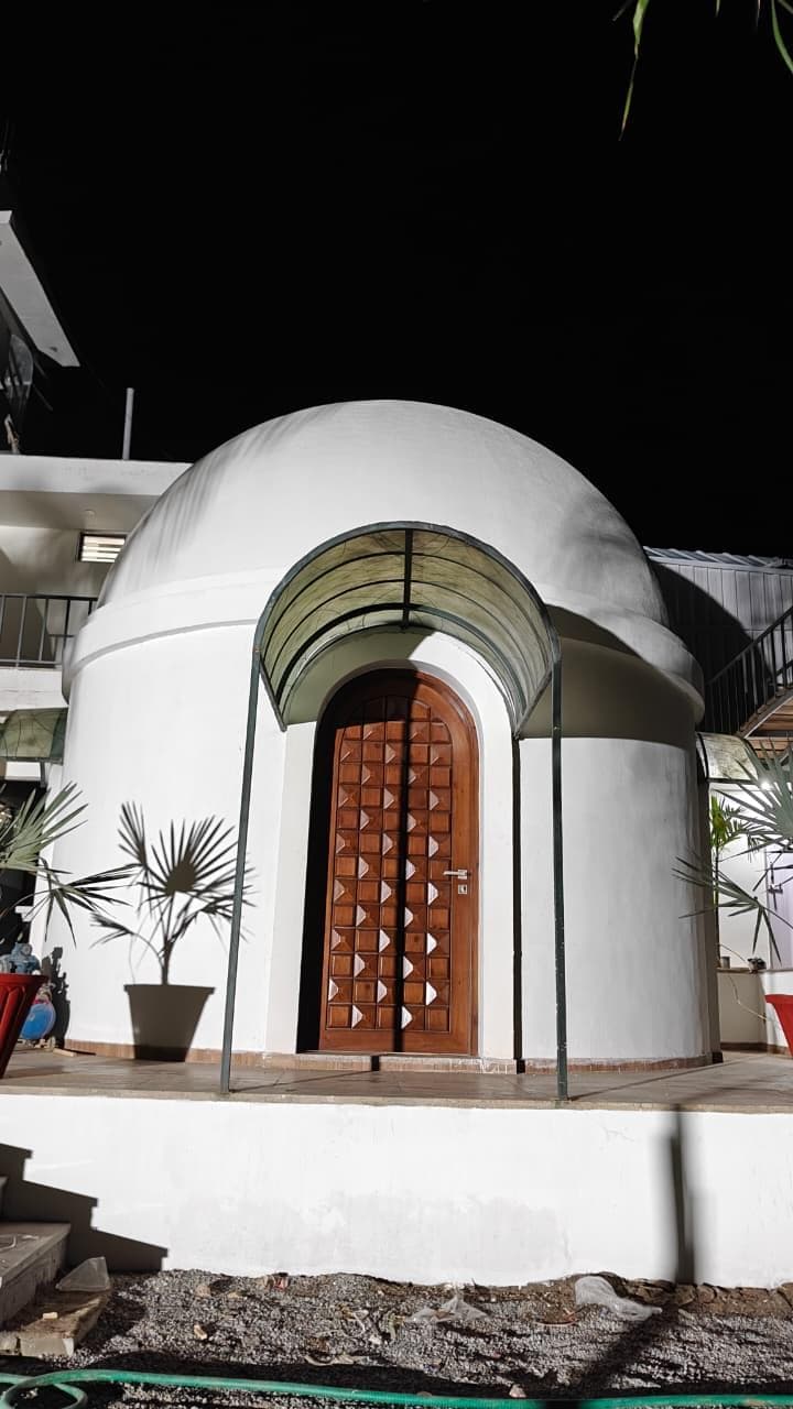 Single dome cottage at night with carved door