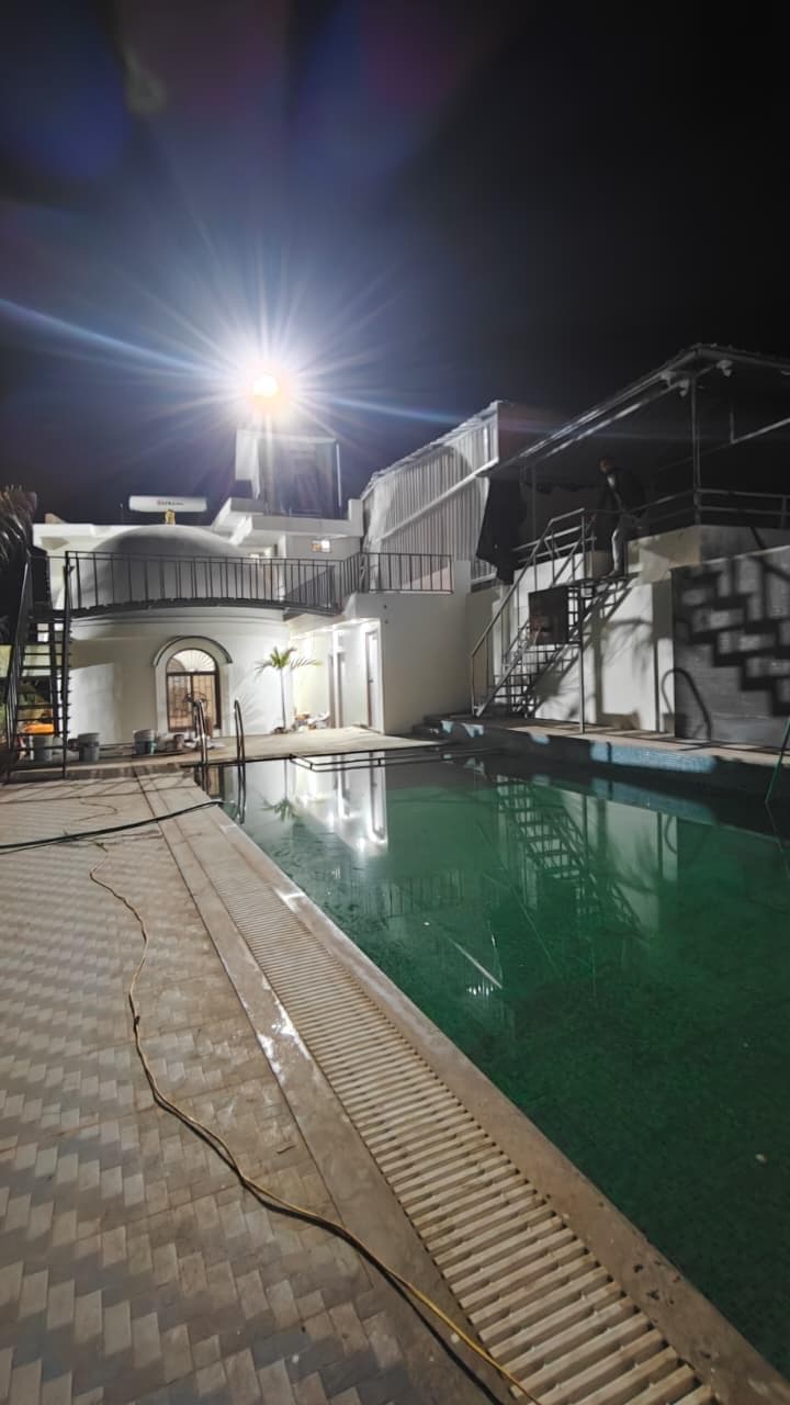 Pool area at night with building and staircase