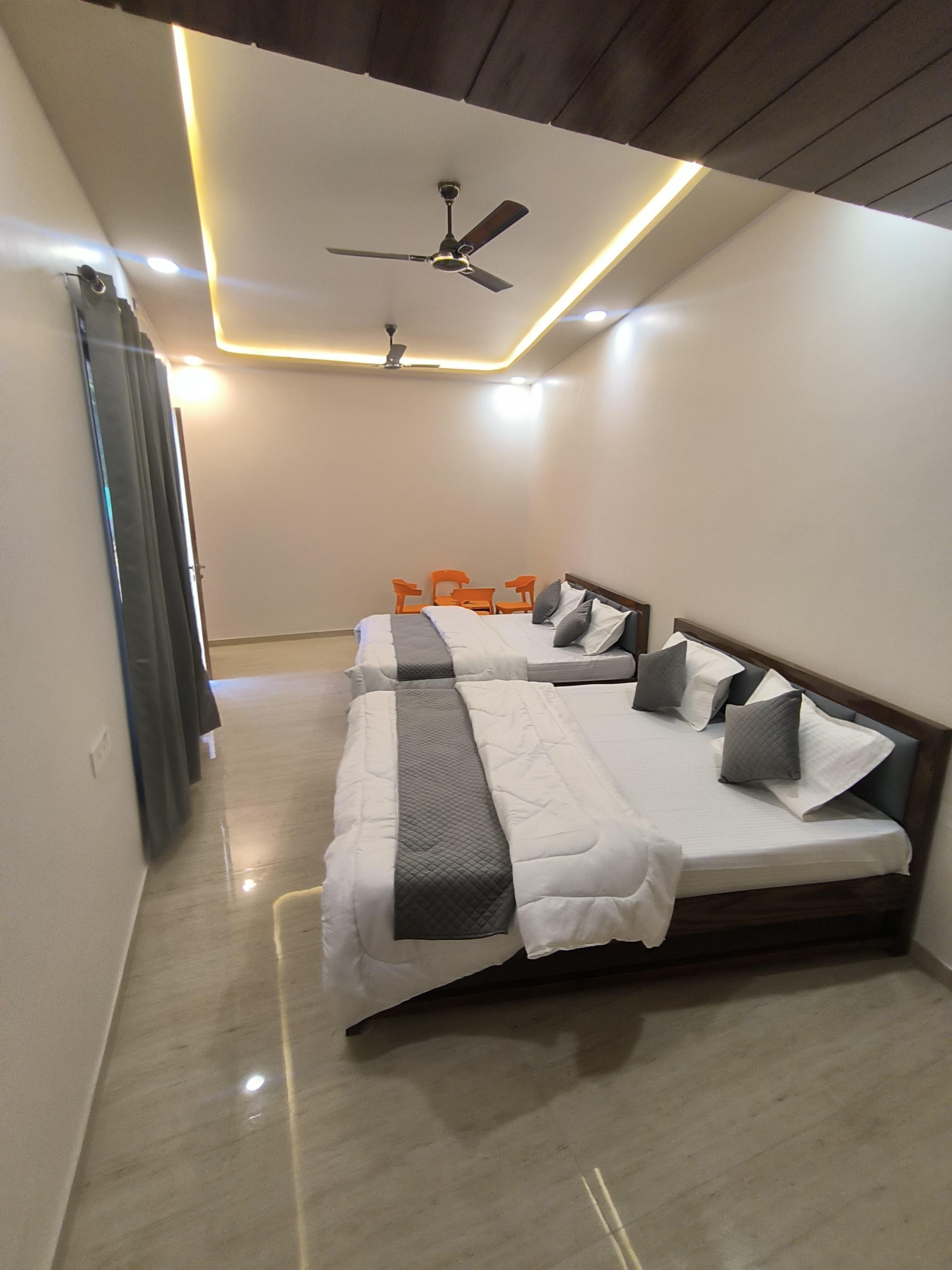 Standard room wide view with LED ceiling and twin double beds